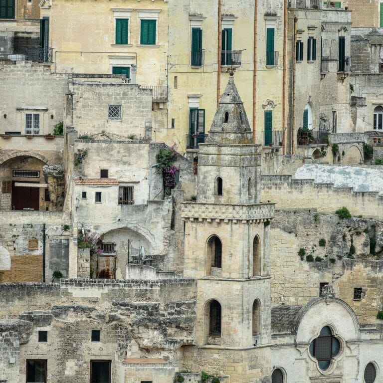 A breathtaking view of Matera's ancient Sassi district, showcasing its iconic stone-carved dwellings nestled into the rugged cliffs of the Gravina valley, a UNESCO World Heritage site