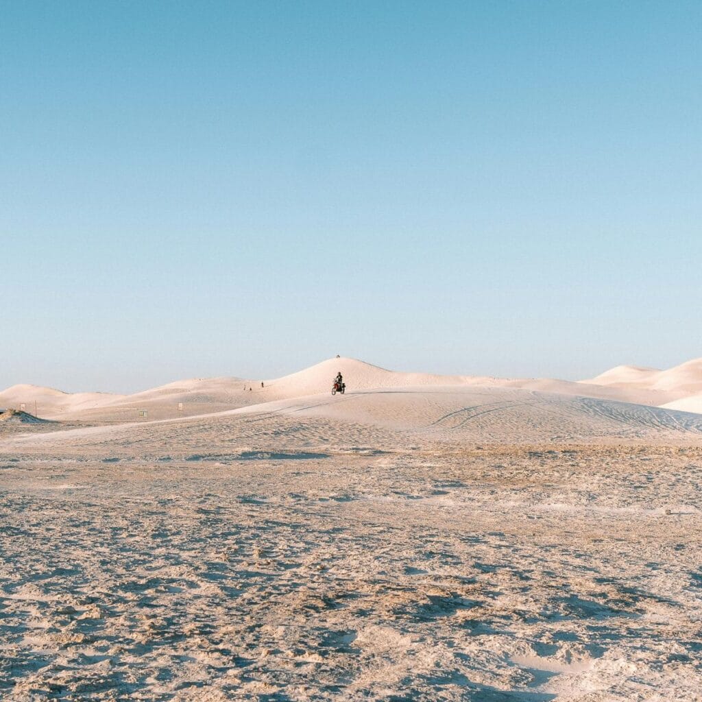 A stunning sunset over the Lancelin Dunes, with warm orange and pink hues lighting up the sky