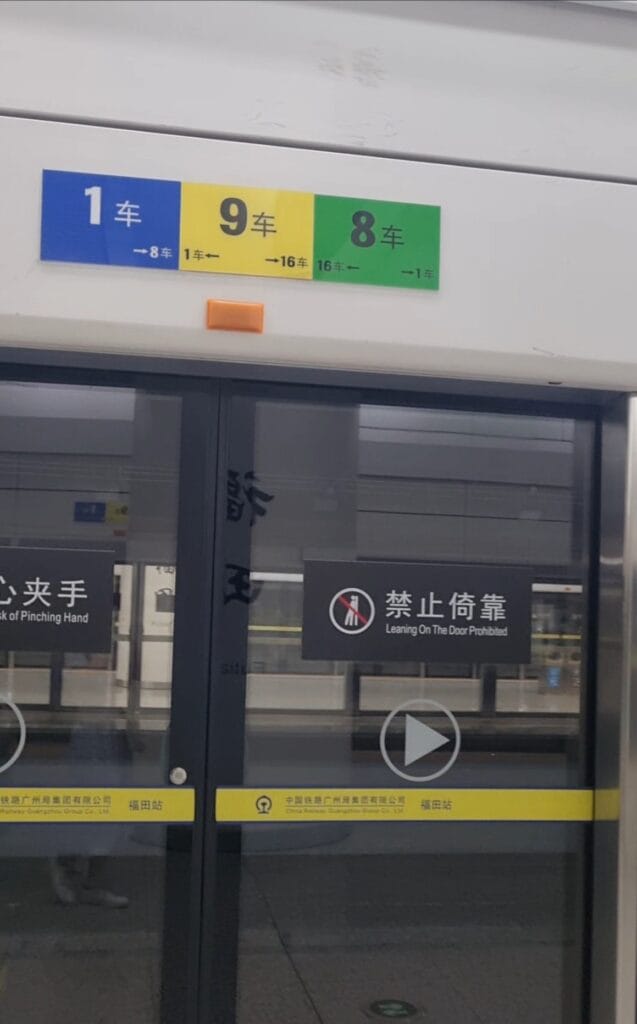 Color-coded carriage numbers on China high-speed rail platform, with green, yellow, and blue markers showing boarding locations for different train cars