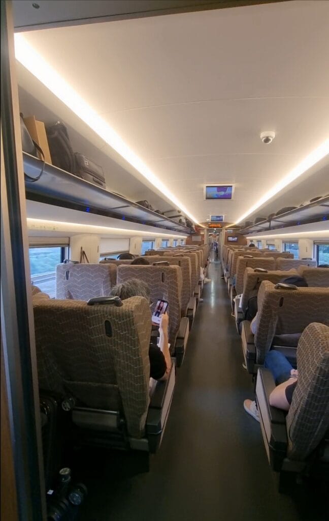 Second class seats on China high-speed train, arranged in a 3-2 configuration, offering comfortable seating and foldable tray tables for budget-friendly travel