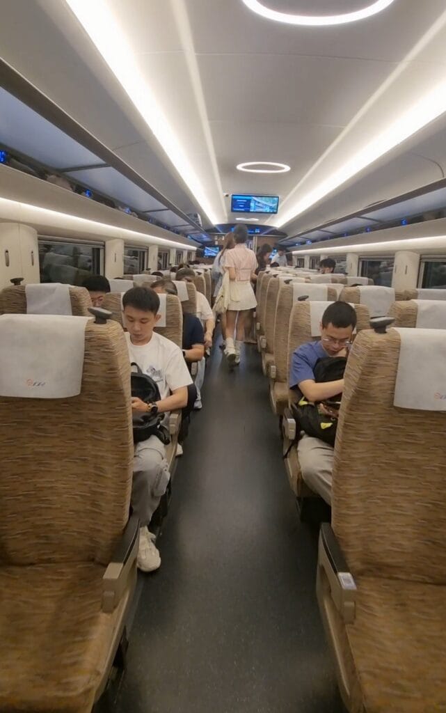 First class seats on China high-speed train, arranged in a 2-2 configuration with wide, cushioned seats, extra legroom, and adjustable backrests