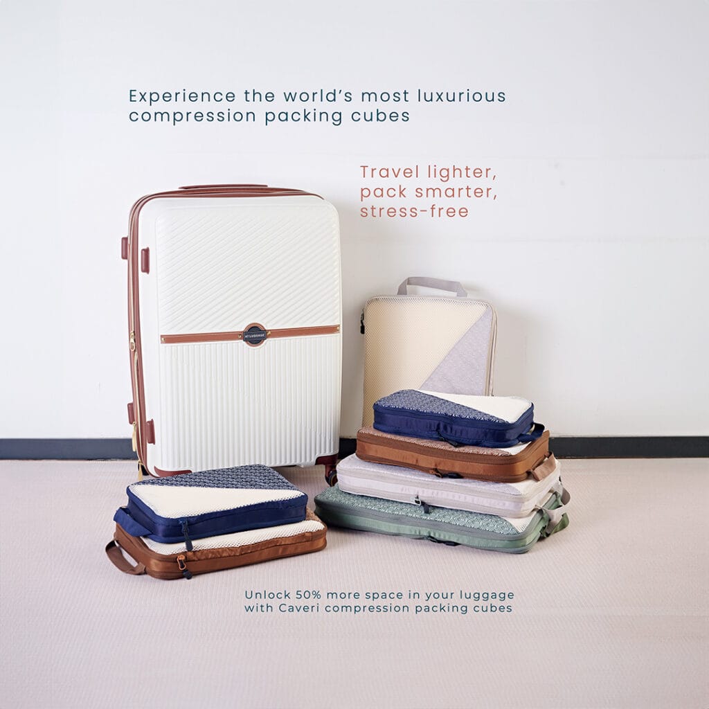 Caveri compression packing cubes in four sizes and colours, neatly stacked beside a closed suitcase, ready for packing.